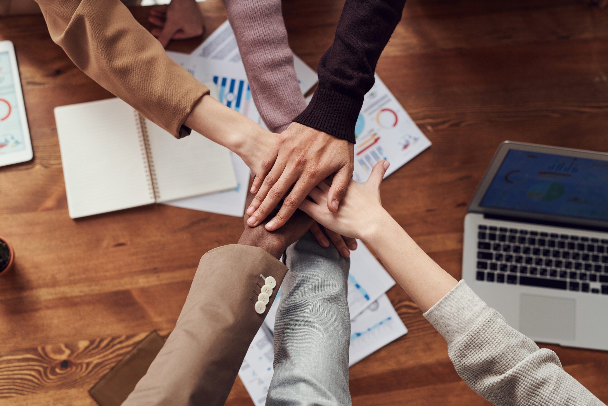 The picture is of people joining hands around a work table to show that they are happy about temping for various reasons detailed in the blog